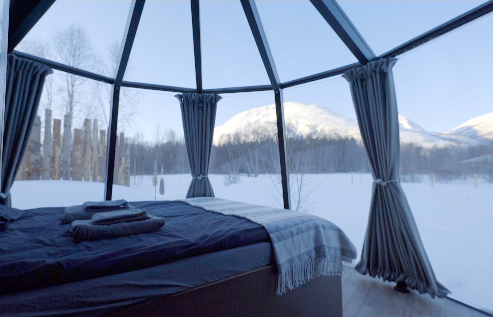 AuroraHut bed with views to snowy mountains