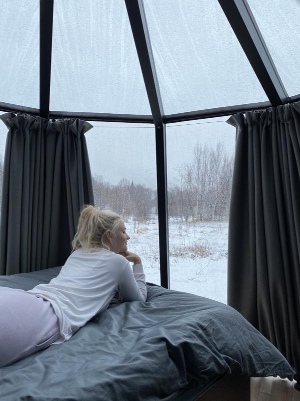 Guest relaxing in the AuroraHut in winter